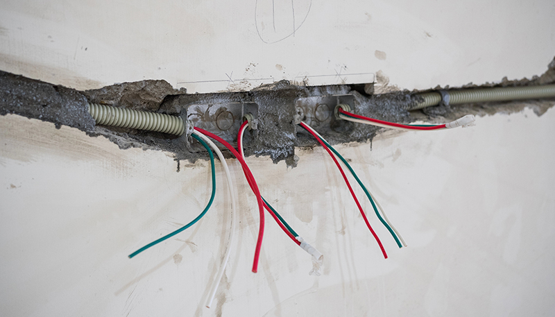 Residential Electrician 2 Exposed electrical wiring in a wall during a residential rewiring project