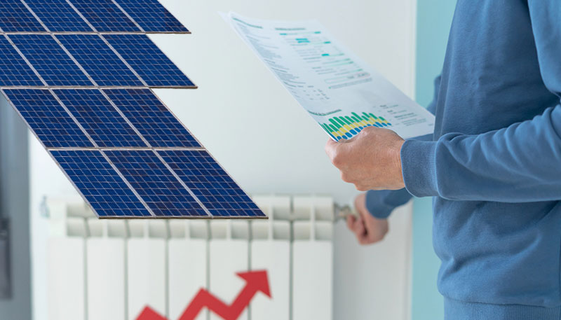 Solar Panel Installation 1 Person reviewing a rising energy bill next to solar panels and an indoor heater